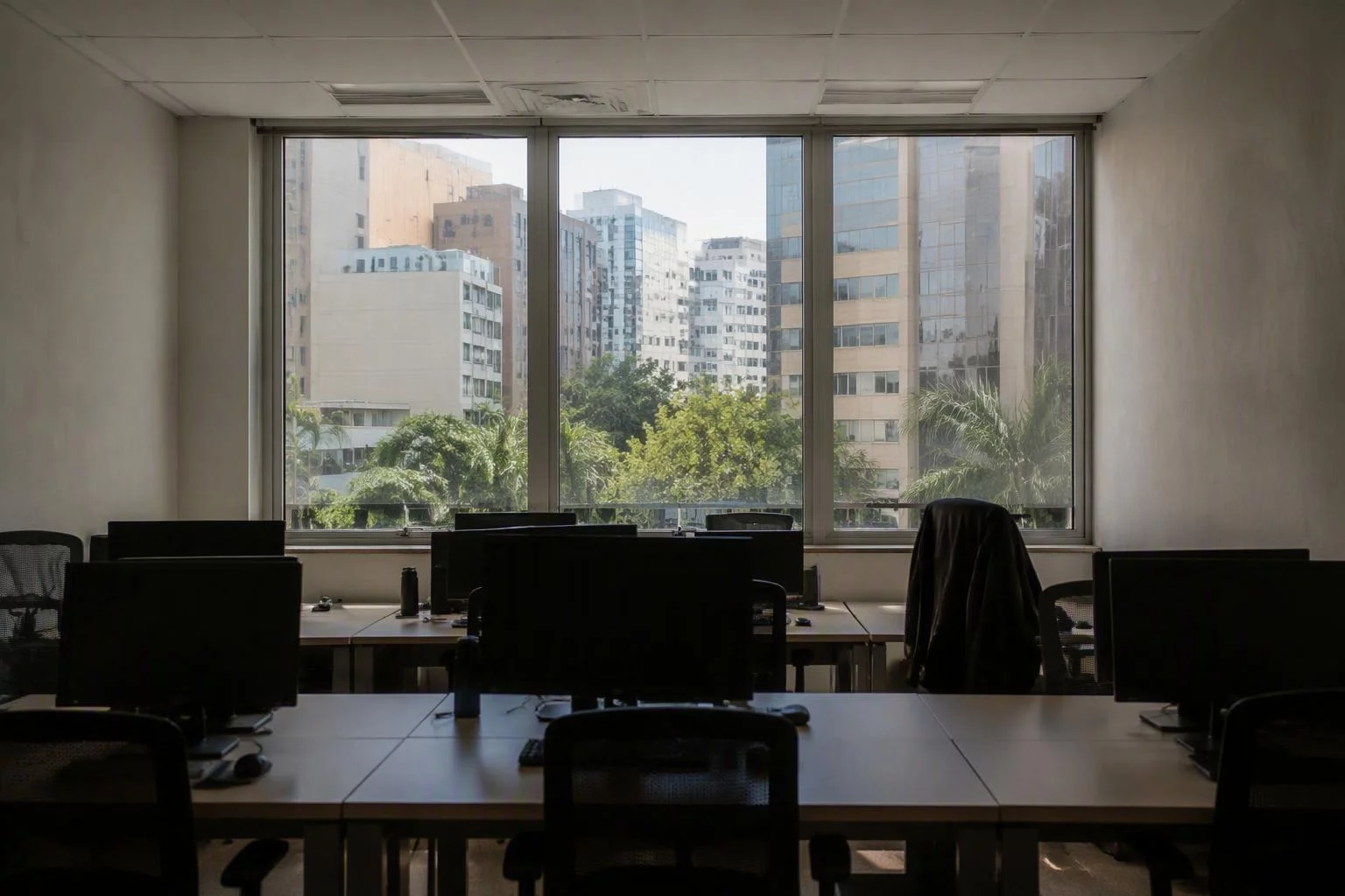 Janela do escritório com mesas vazias em primeiro plano